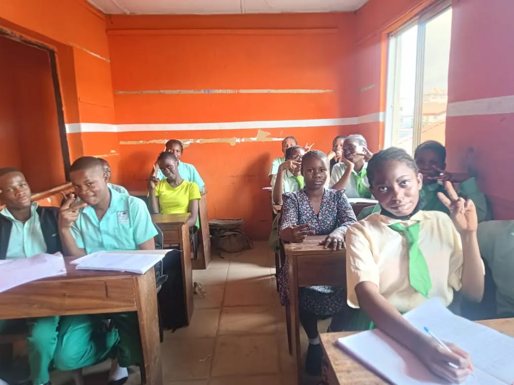 Secondary students at wooden desks in a bright classroom